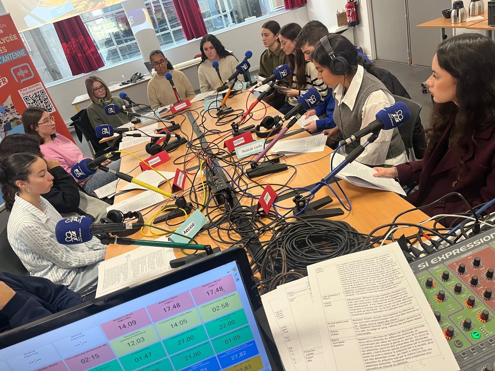 Des lycéens en direct dans le studio Radio Lycée, micros et casques sur la table de régie.